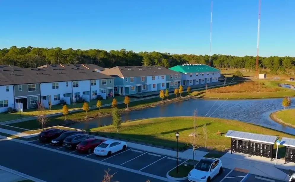 Aerial view of a Westchase, Florida townhome community beside a retention pond and conservation area